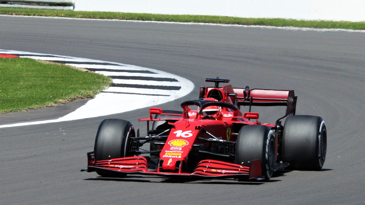 a man driving a red race car on a track, ferrari logo on it's chest, helmet is off, taken in 2 0 2 0, f11:10