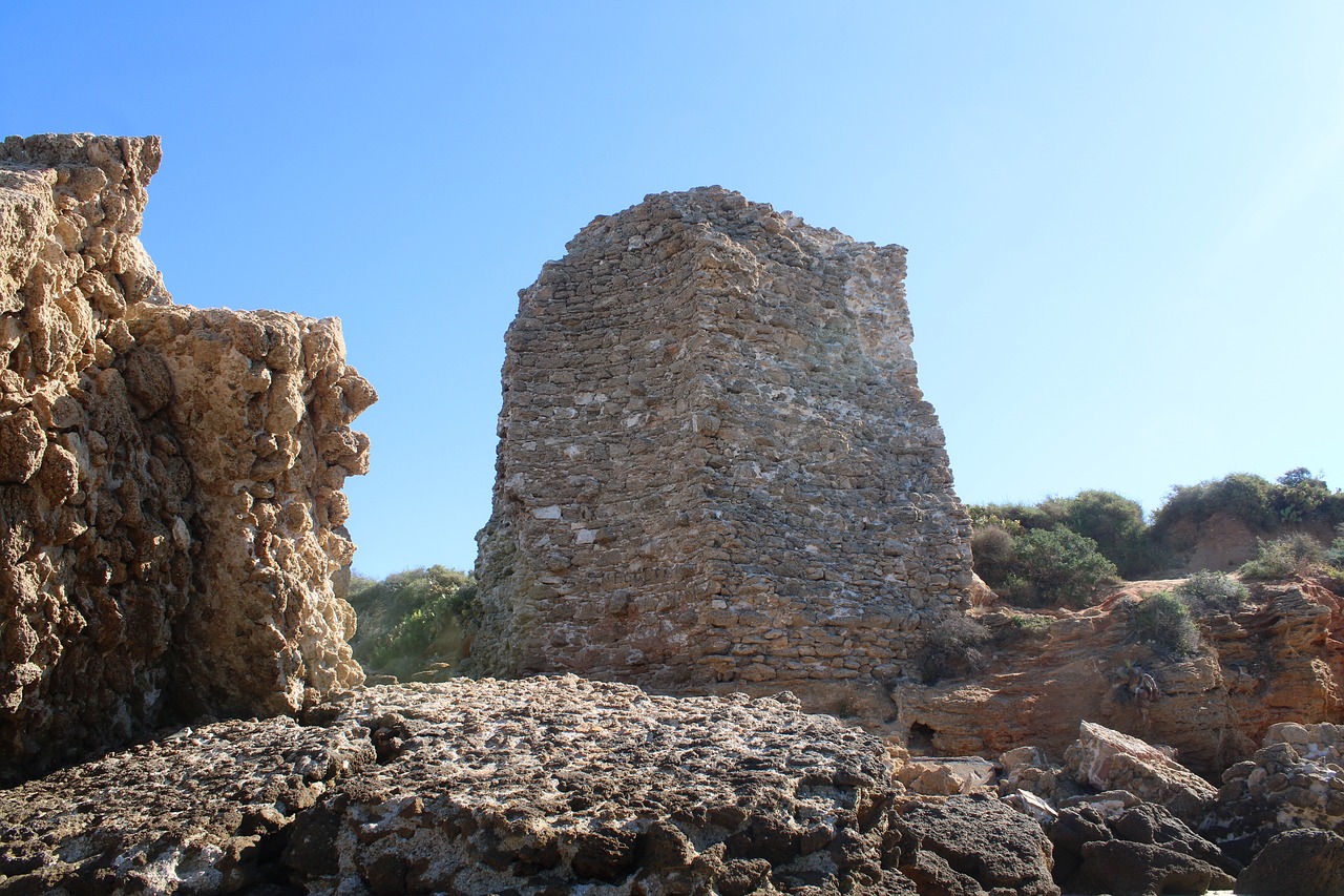 a stone tower sitting on top of a rocky hillside, sand piled in corners, byzantine, rocha, brick