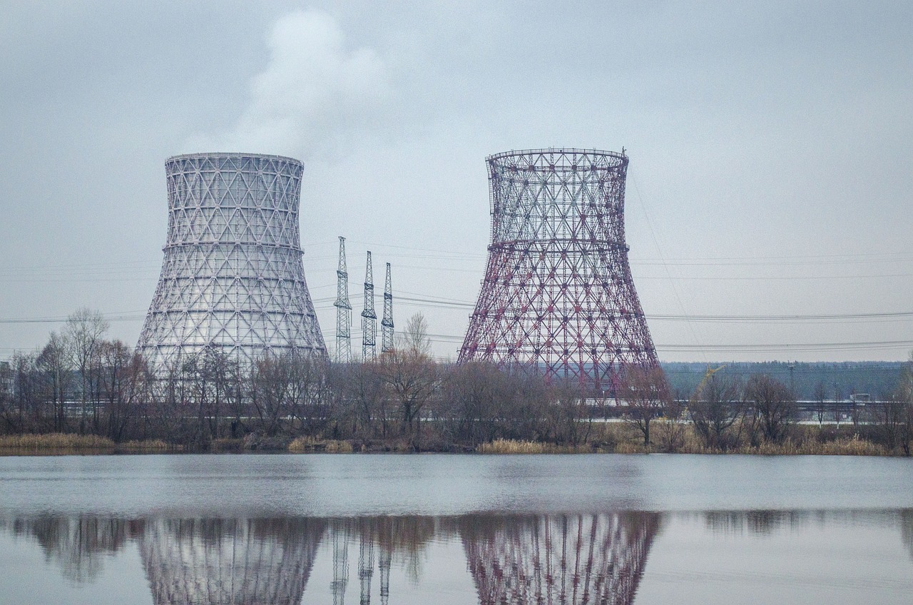 two cooling towers next to a body of water, a portrait, by Petr Brandl, shutterstock, nuclear art, typical russian atmosphere, pylons, photo taken from the ground, building along a river