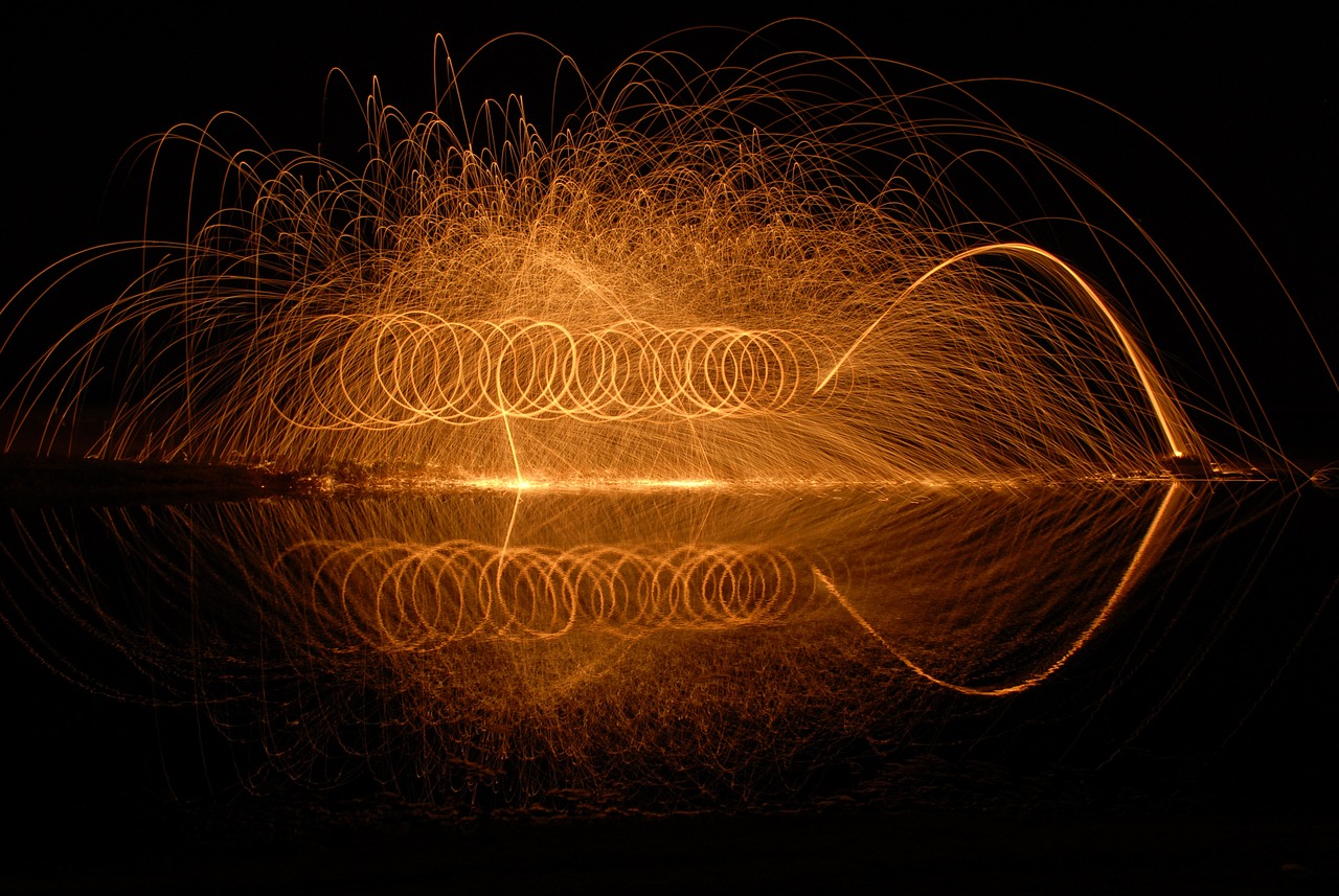 a close up of a light painting on a body of water, by Sebastian Spreng, flickr, sparks of fire flying, orange halo, intricate sparkling atmosphere, shot on a 2 0 0 3 camera