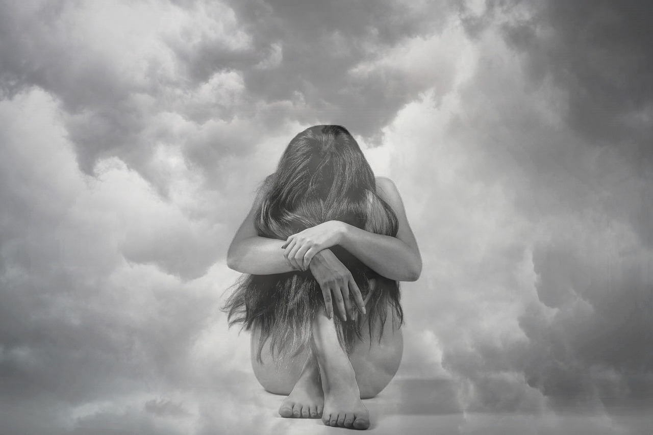 a black and white photo of a woman sitting on the ground, inspired by Anna Füssli, surrealism, hyper realistic clouds, hugging her knees, david kassan, sad sky