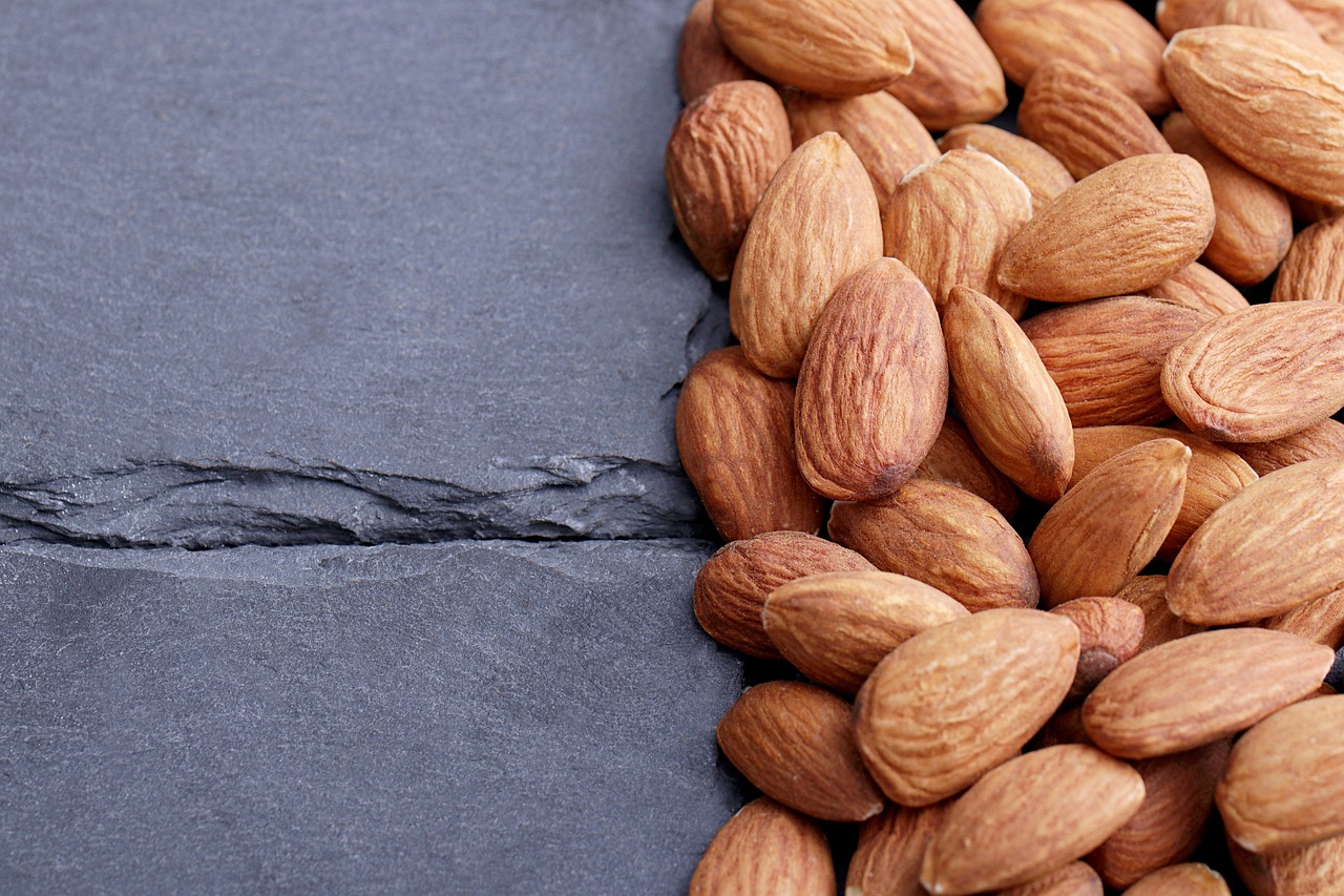 a pile of almonds sitting on top of a table, a portrait, pexels, slate, background image, thumbnail, 1/320