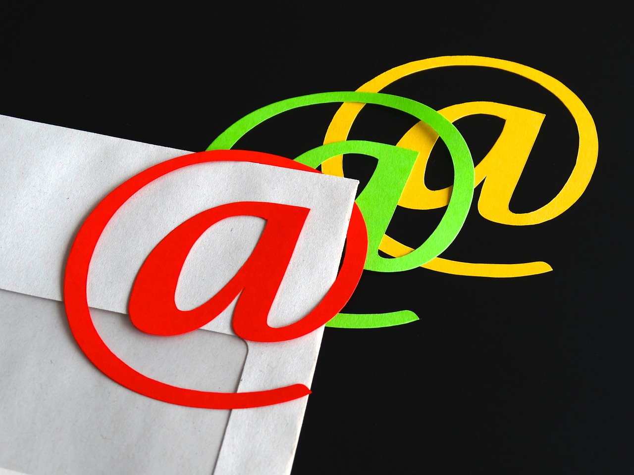 a close up of an email symbol on a piece of paper, a digital rendering, by Allen Jones, letterism, with a black background, various colors, trio, case