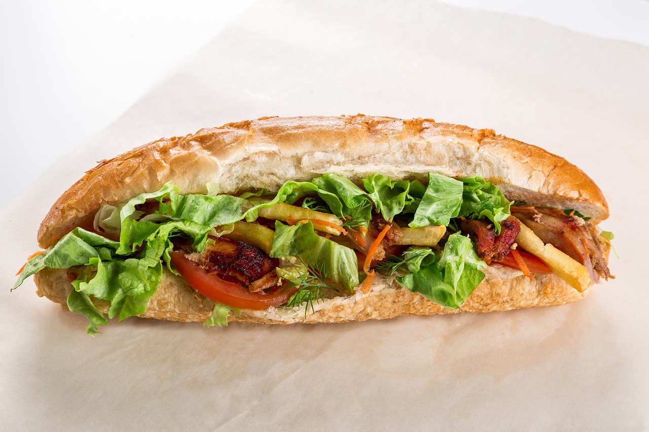 a close up of a sandwich with lettuce and tomatoes, a portrait, by Edward Avedisian, parchment paper, productphoto, subway, side view of a gaunt