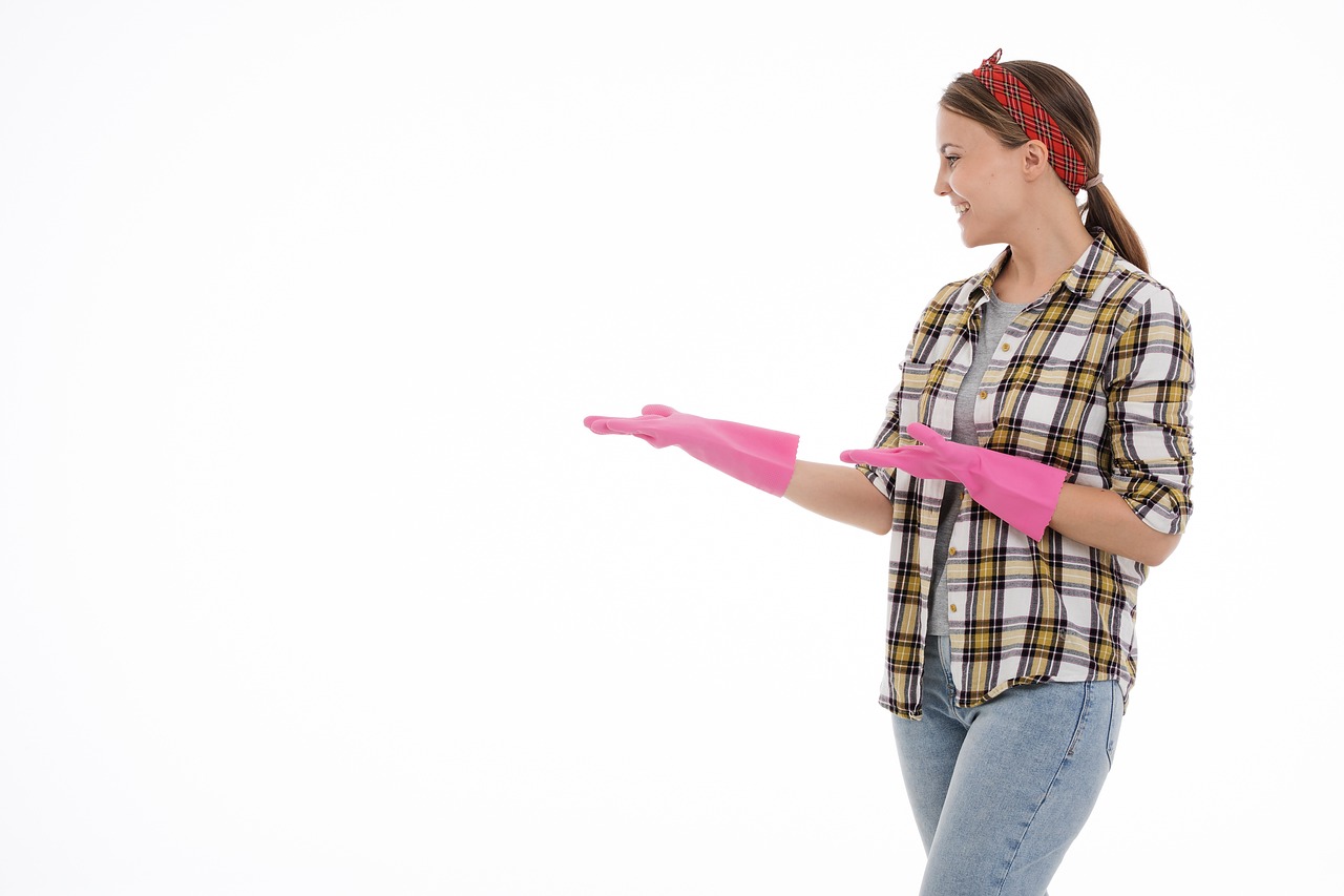 a woman in a plaid shirt holding a pink glove, shutterstock, plasticien, majestic sweeping action, happy girl, clean and empty, standing sideways