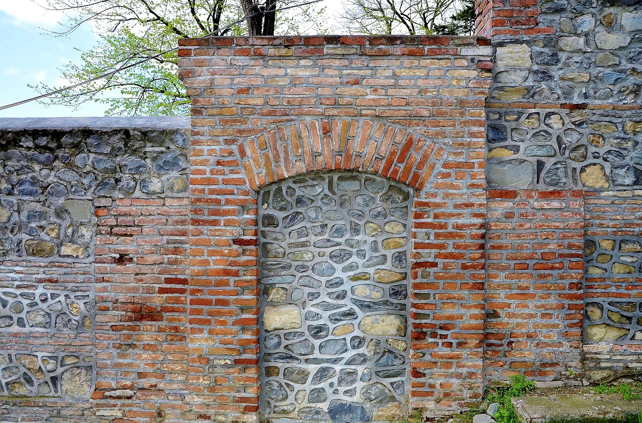 a red fire hydrant sitting in front of a brick wall, by Alexander Fedosav, romanesque, stone gate to the dark cave, 1759, wall structure, back arched