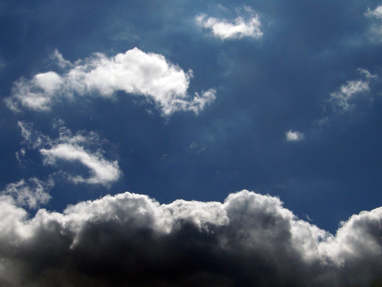 a jetliner flying through a cloudy blue sky, a photo, by Alexander Scott, flickr, sunlight through cumulus, blackened clouds cover sky, a close-up, 4 0 9 6