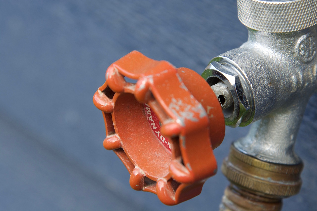 a close up of a fire hydrant on the side of a building, shutterstock, fixing a leaking sink, 555400831, version 3, reddish