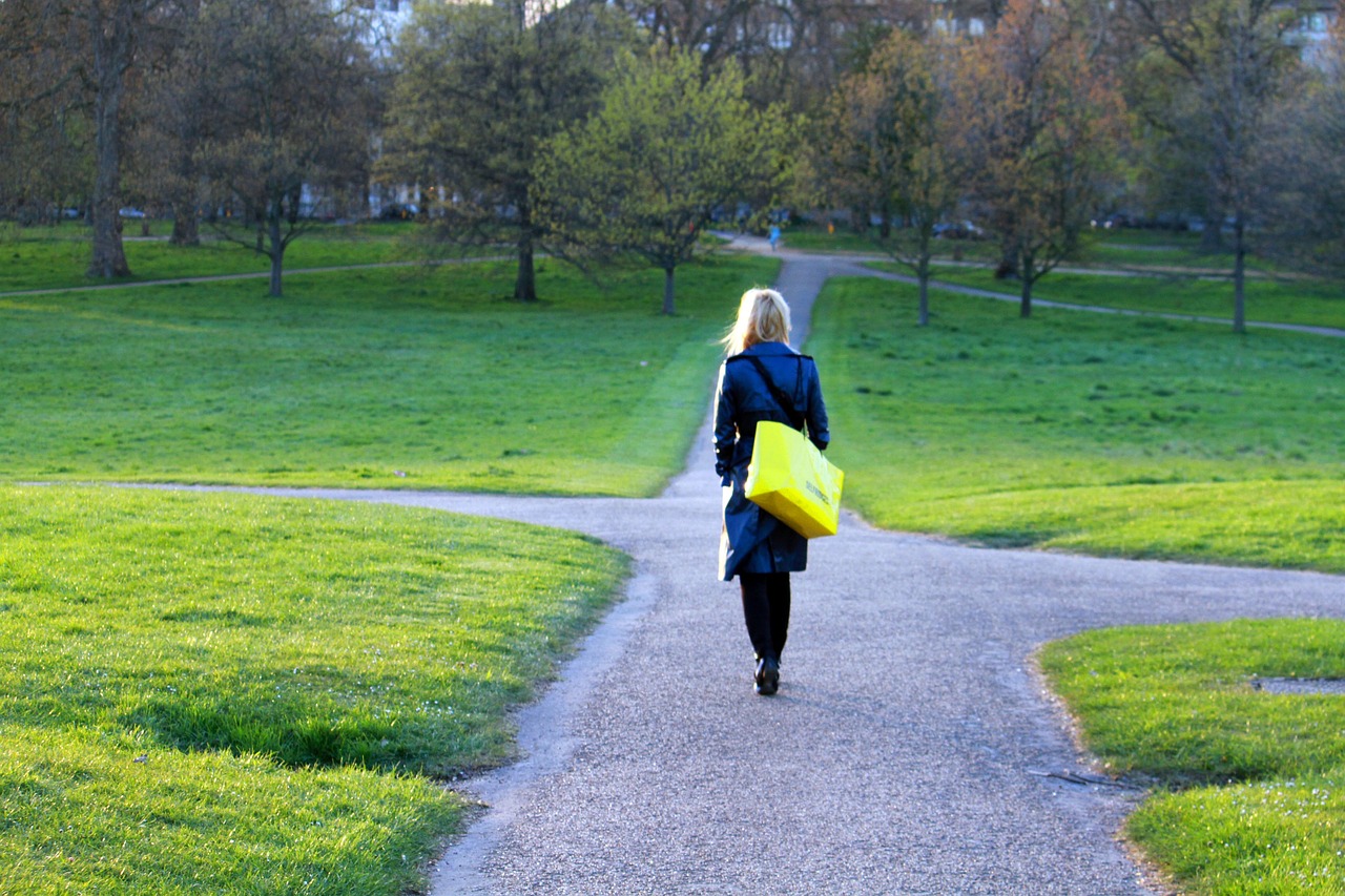 a woman walking down a path carrying a yellow frisbee, by senior artist, happening, in london, bag, green spaces, loneliness