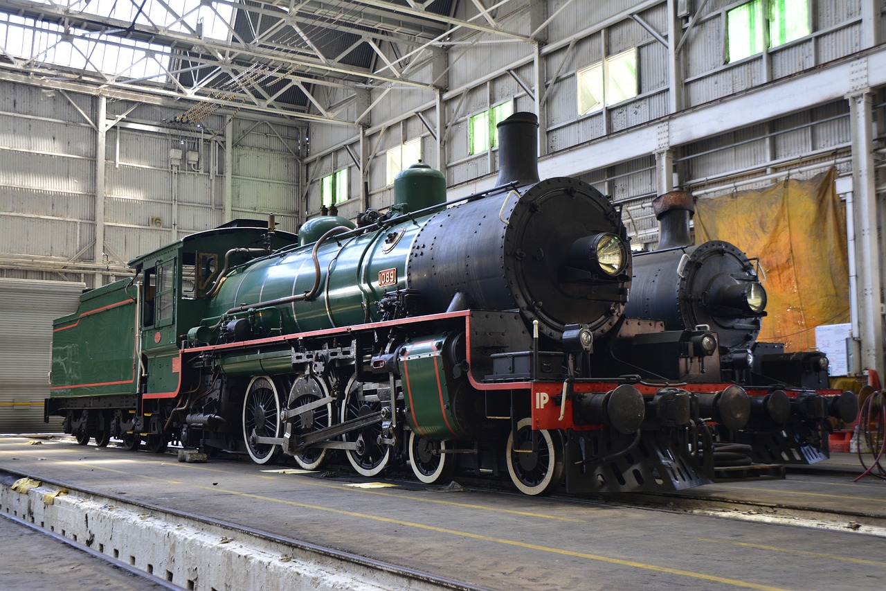 a green and black train sitting inside of a building, shutterstock, engines, australian, 3 4 5 3 1, steam engine