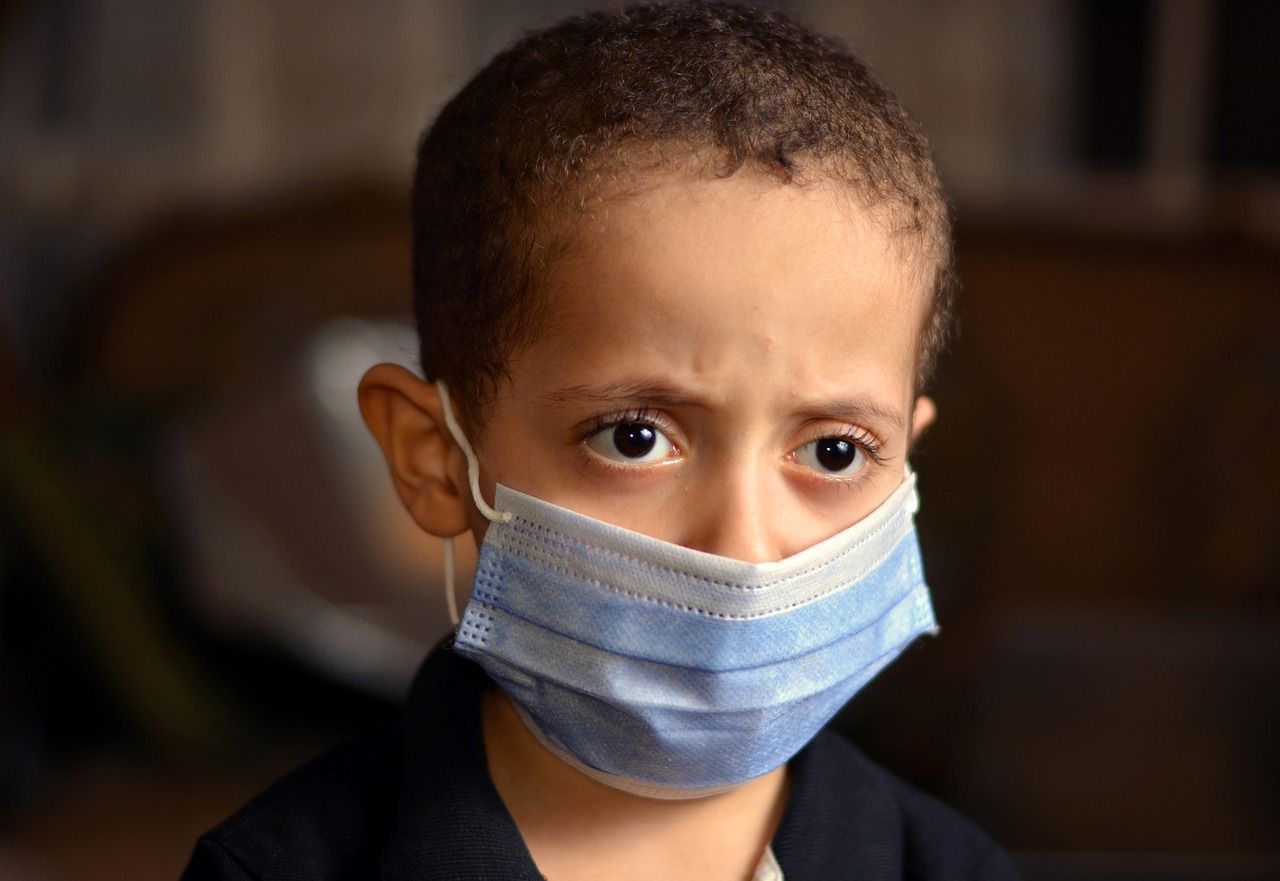 a close up of a child wearing a face mask, a picture, hurufiyya, disappointed, egypt, medical mask, 4 0 0 0 0 0