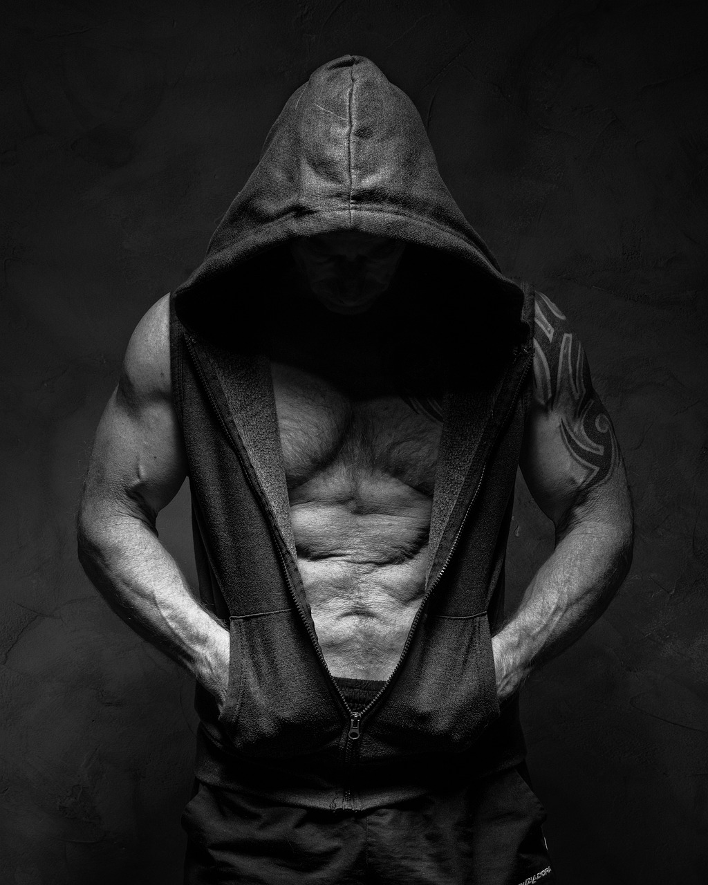 a black and white photo of a man in a hoodie, by Adam Marczyński, pexels contest winner, realism, abdominal muscles, hr giger muscles, wearing a low cut tanktop, hood and cape