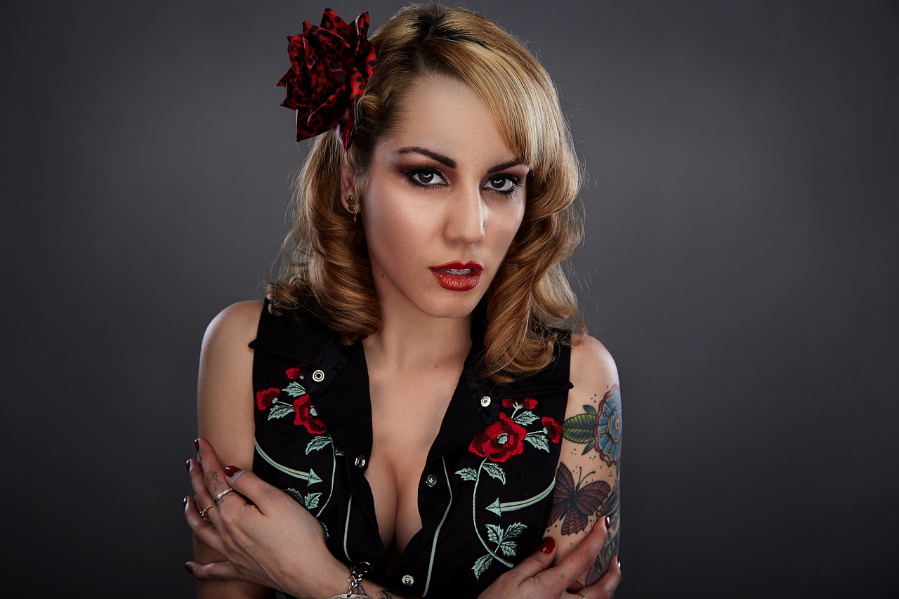 a woman with tattoos and a flower in her hair, a portrait, inspired by Earle Bergey, flickr, rockabilly band 1950s, photo from a promo shoot, vests and corsets, lorena avarez
