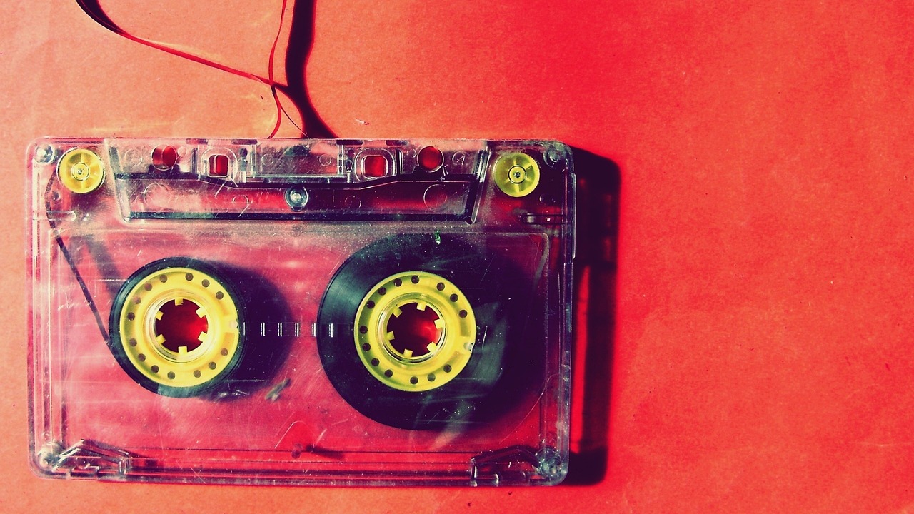 a close up of a cassette on a red surface, by Alexander Deyneka, pexels, pop art, yellow wallpaper, vintage - w 1 0 2 4, tribal red atmosphere, mixed medias