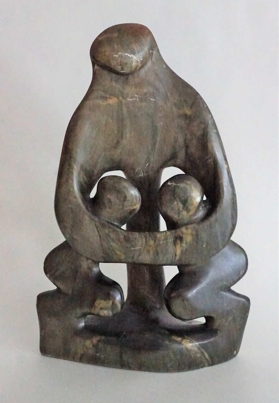 a statue of a woman holding a child, inspired by Ossip Zadkine, bog oak, asian art, sitting cross-legged, 6 0's