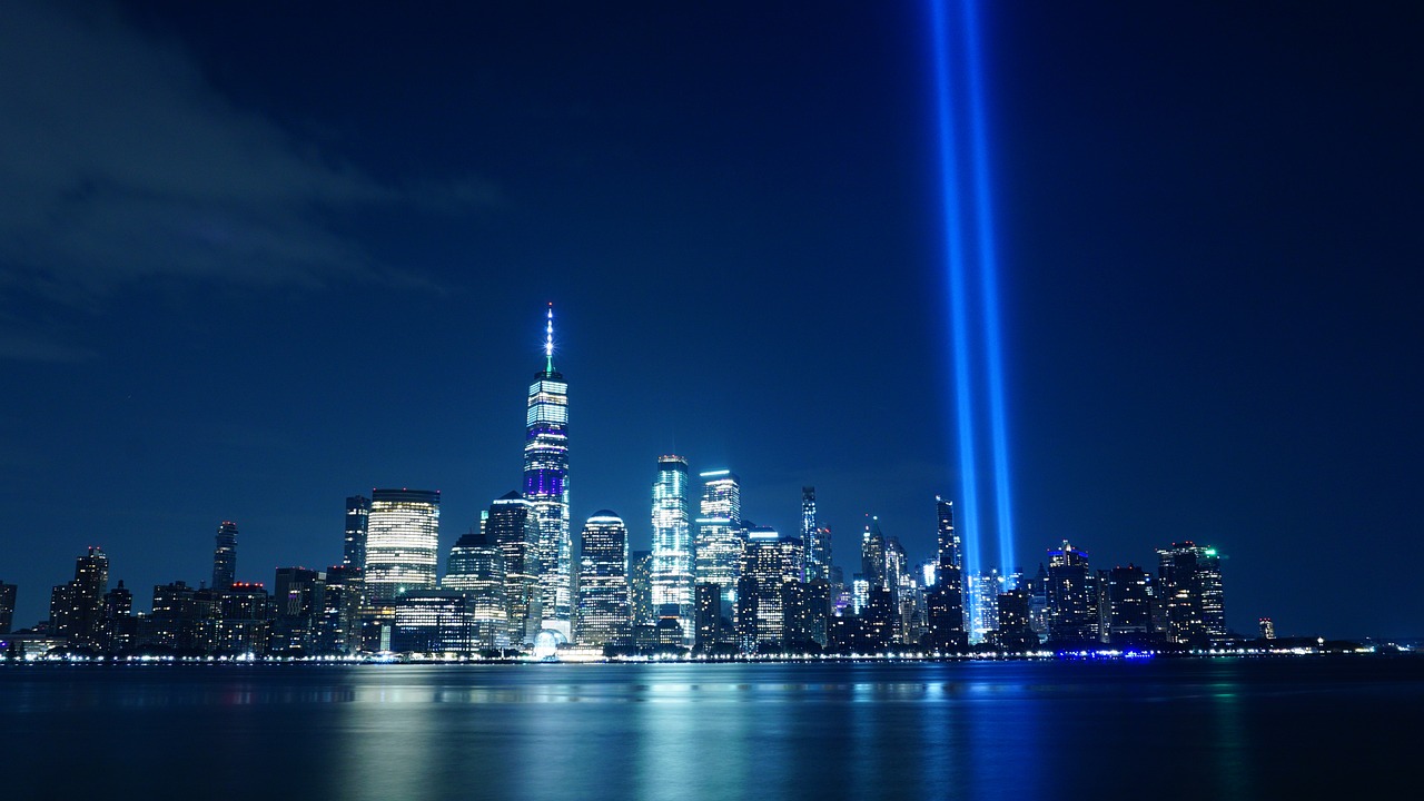 a view of the new york city skyline at night, a picture, by Joseph Pisani, remembrance, lightbeams shining through, humanity's last sacrifice, beautiful blue lights