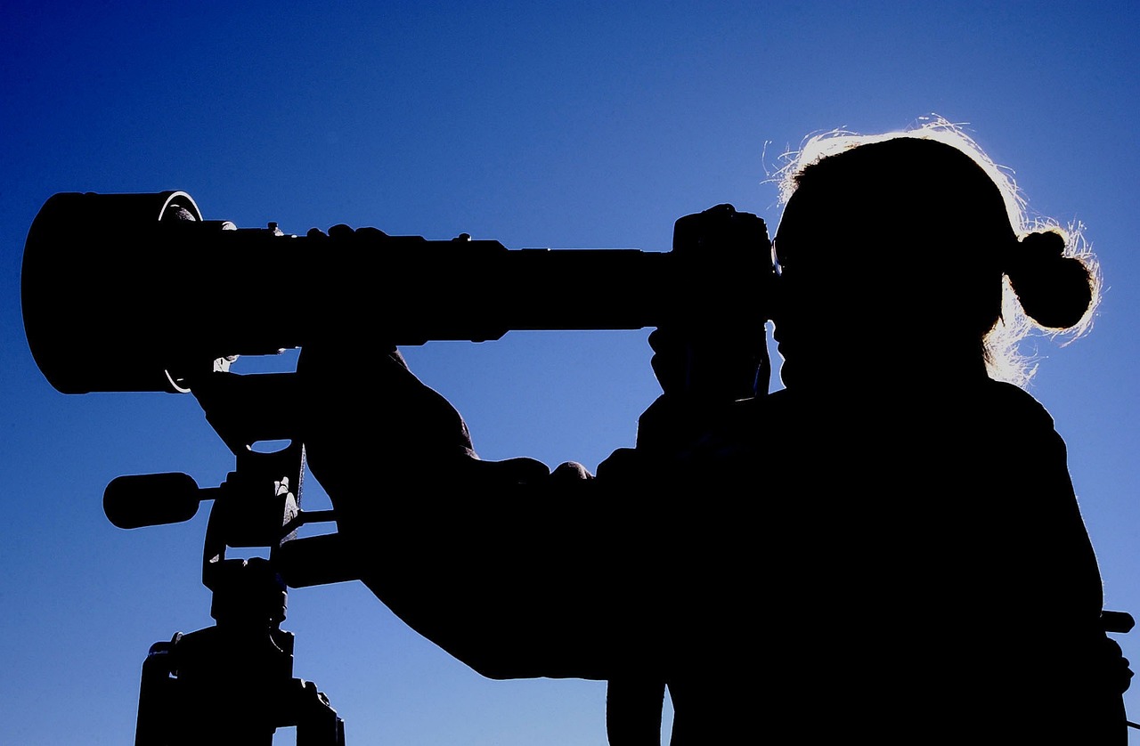 a silhouette of a person with a camera on a tripod, by John Murdoch, hurufiyya, big monocular, istockphoto, military weaponry, macro perspective