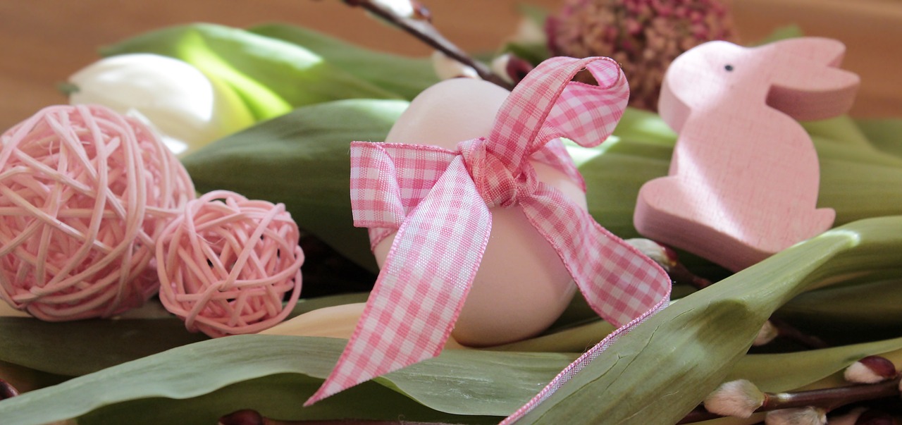 a basket filled with eggs sitting on top of a table, a picture, by Anna Haifisch, pixabay, ornamental bow, white and pink cloth, checkered pattern, ribbon