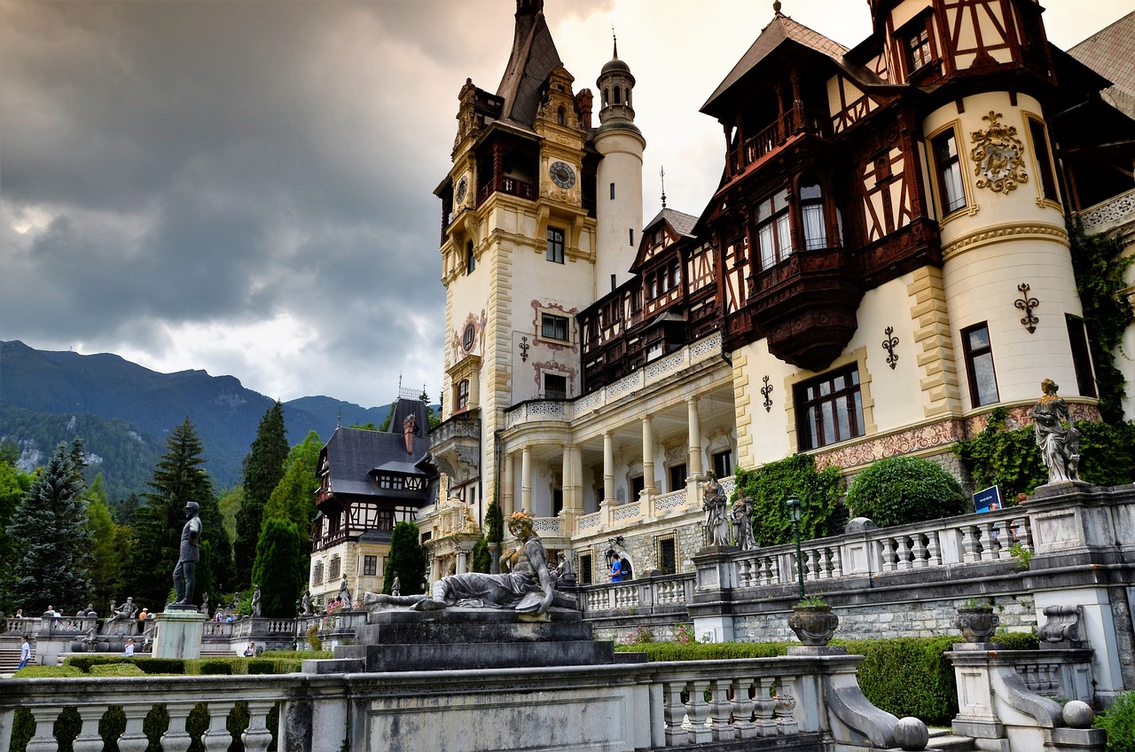 a large building with a fountain in front of it, a tilt shift photo, inspired by Hristofor Žefarović, shutterstock, art nouveau, transylvanian castle, elaborate carved wood balconies, grand majestic mountains, elegant walkways between towers
