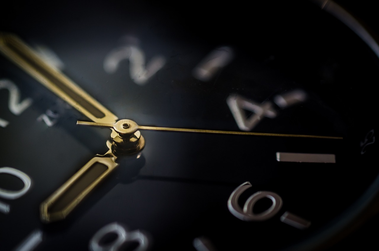 a close up of a clock with roman numerals, a macro photograph, by Thomas Häfner, pexels, precisionism, black and gold colors, stock photo, background depth, slightly turned to the right