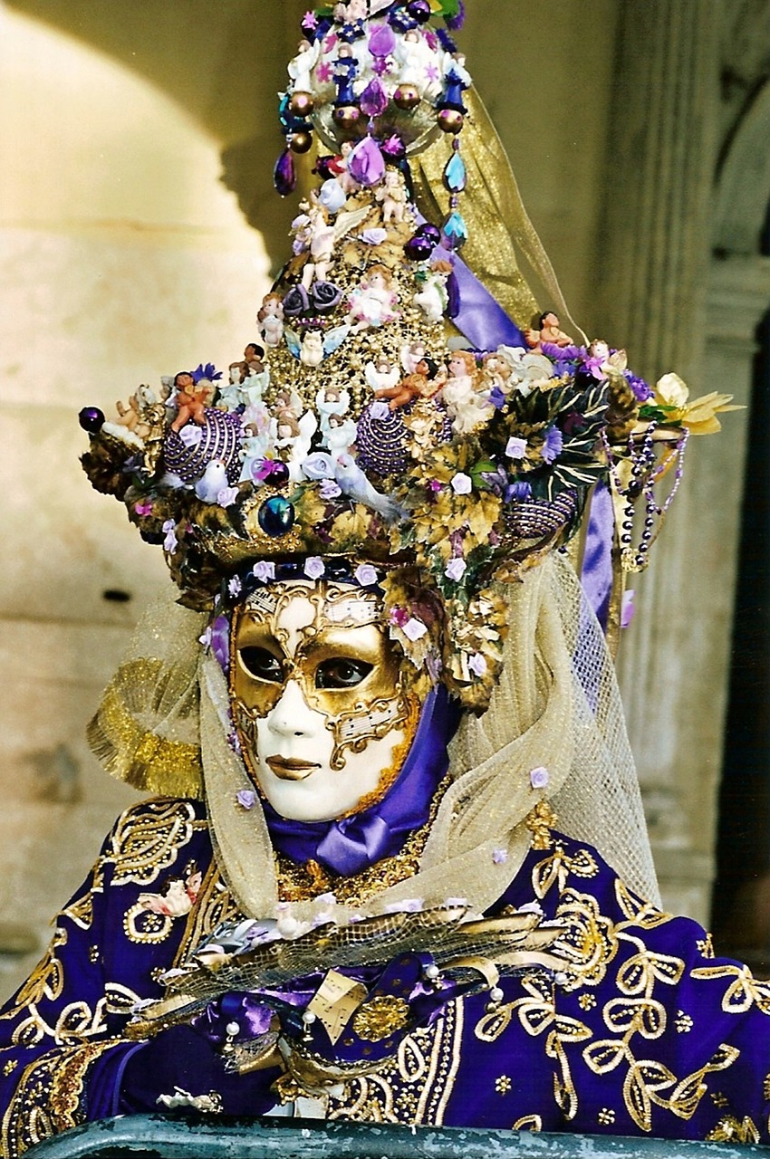 a close up of a person wearing a mask, inspired by Quirizio di Giovanni da Murano, flickr, baroque, draped in silky purple and gold, jeweled headdress, covered with flowers, full dress