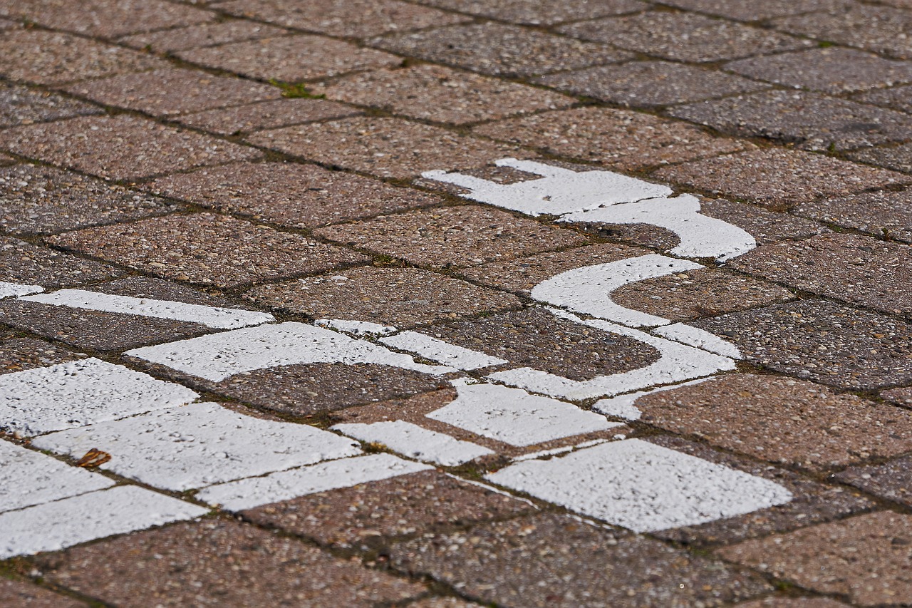 a white street sign sitting on the side of a brick road, a mosaic, by Raymond Normand, unsplash, concrete art, wheelchair, white tracing, detail shot, marble!! (eos 5ds r