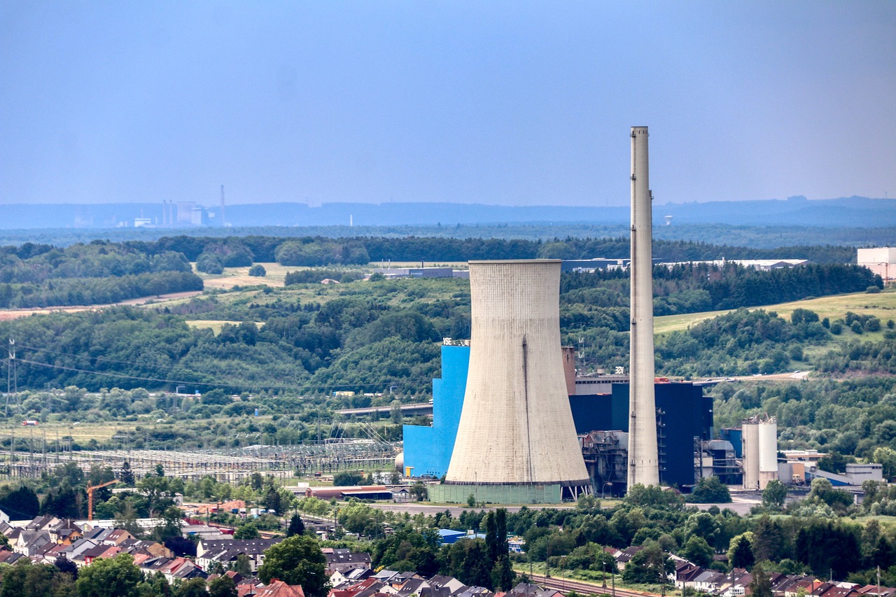 a large power plant sitting on top of a lush green hillside, a tilt shift photo, by Hans Schwarz, shutterstock, bauhaus, high detail photo of a deserted, gigantic tower, view from slightly above, stock photo