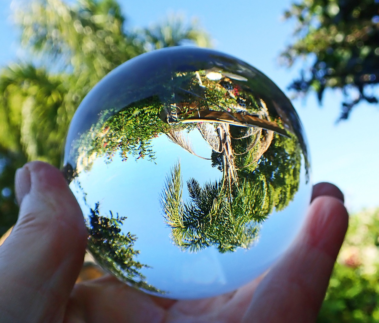 a close up of a person holding a glass ball, a picture, by Jon Coffelt, pixabay, fisheye!!!, hyperrealistic flickr:5, transparent crystal, landscape shot