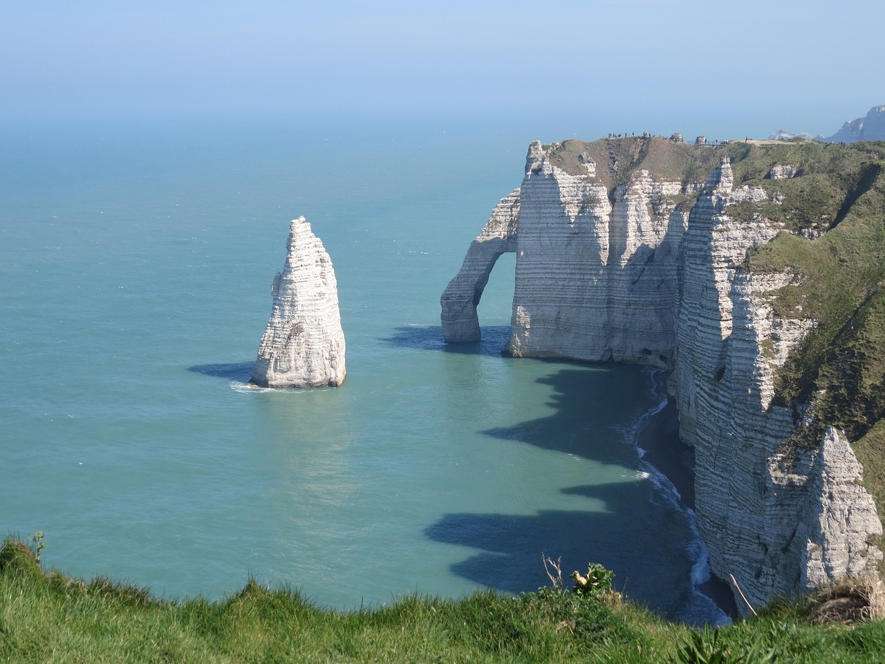 a rock formation in the middle of a body of water, a picture, by Raphaël Collin, chalk cliffs above, massive arch, very very very beautiful!, far view