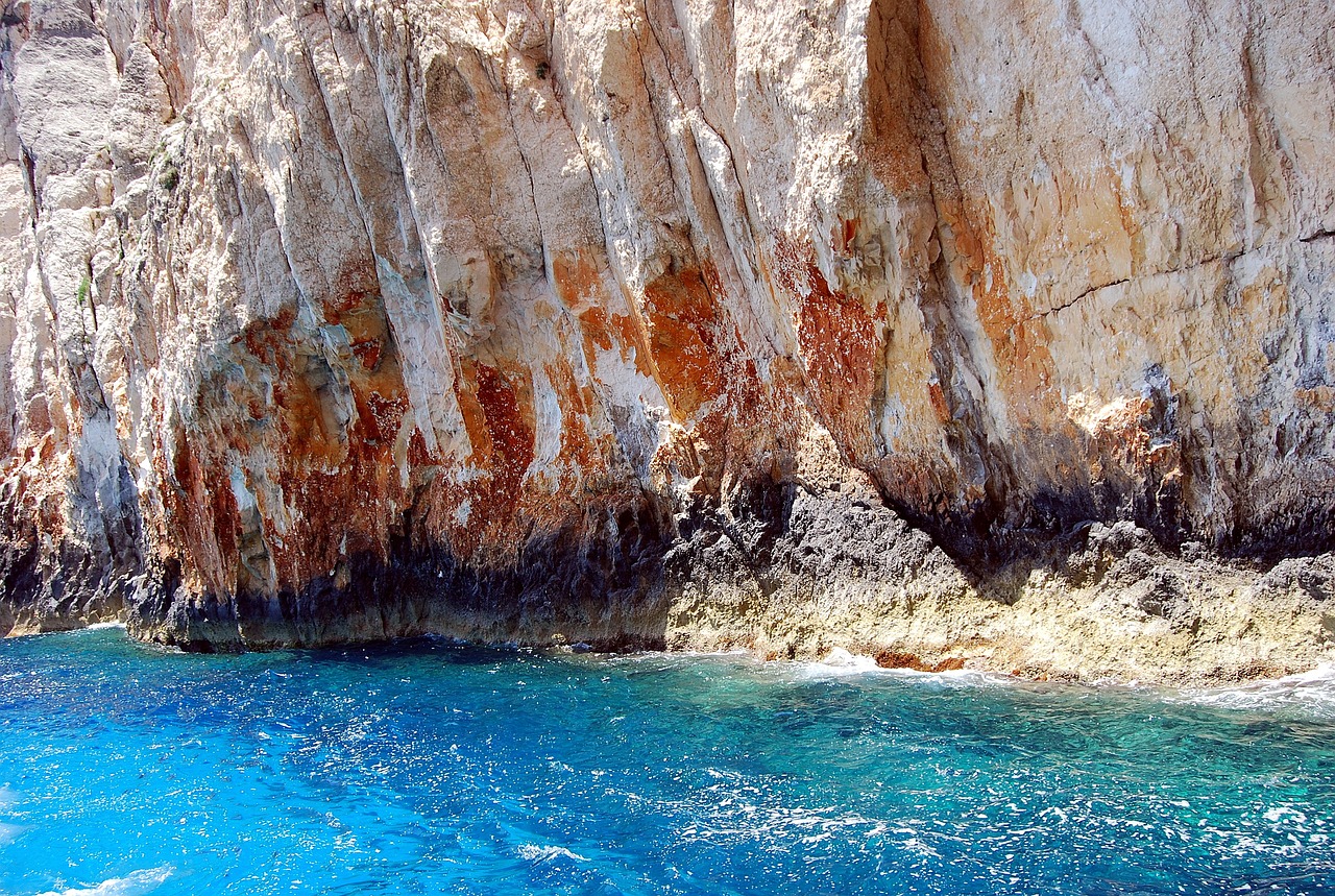 a close up of a body of water near a cliff, a photo, by Tom Carapic, shutterstock, ibiza, cerulean blue and burnt sienna, vivid colors!!, richly textured