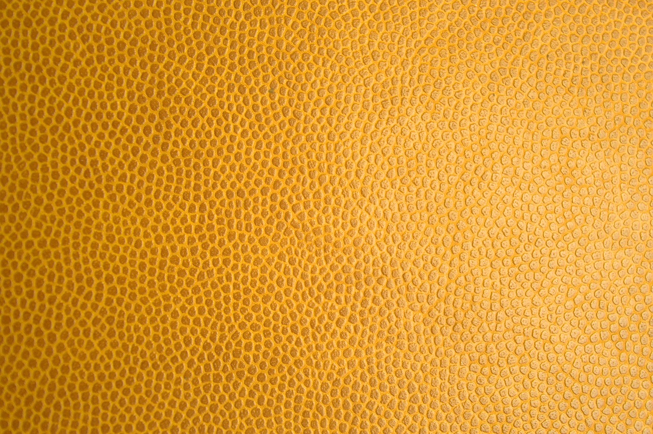 a close up of a yellow leather surface, by Thomas Häfner, dribble, small finely stippled light, lacquered, football, detailed product photo