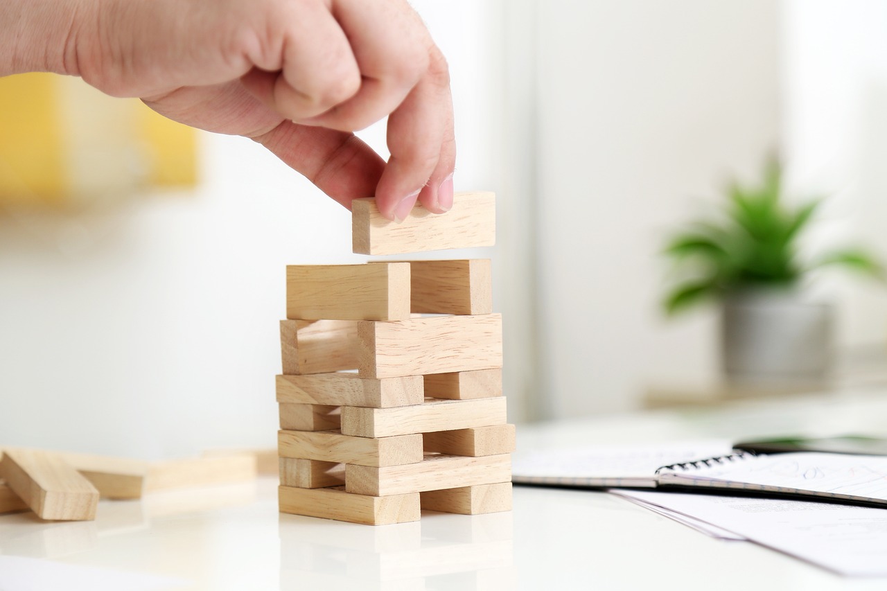a person stacking wooden blocks on top of a desk, shutterstock, miniature product photo, lattice, falling buildings, close - up photo