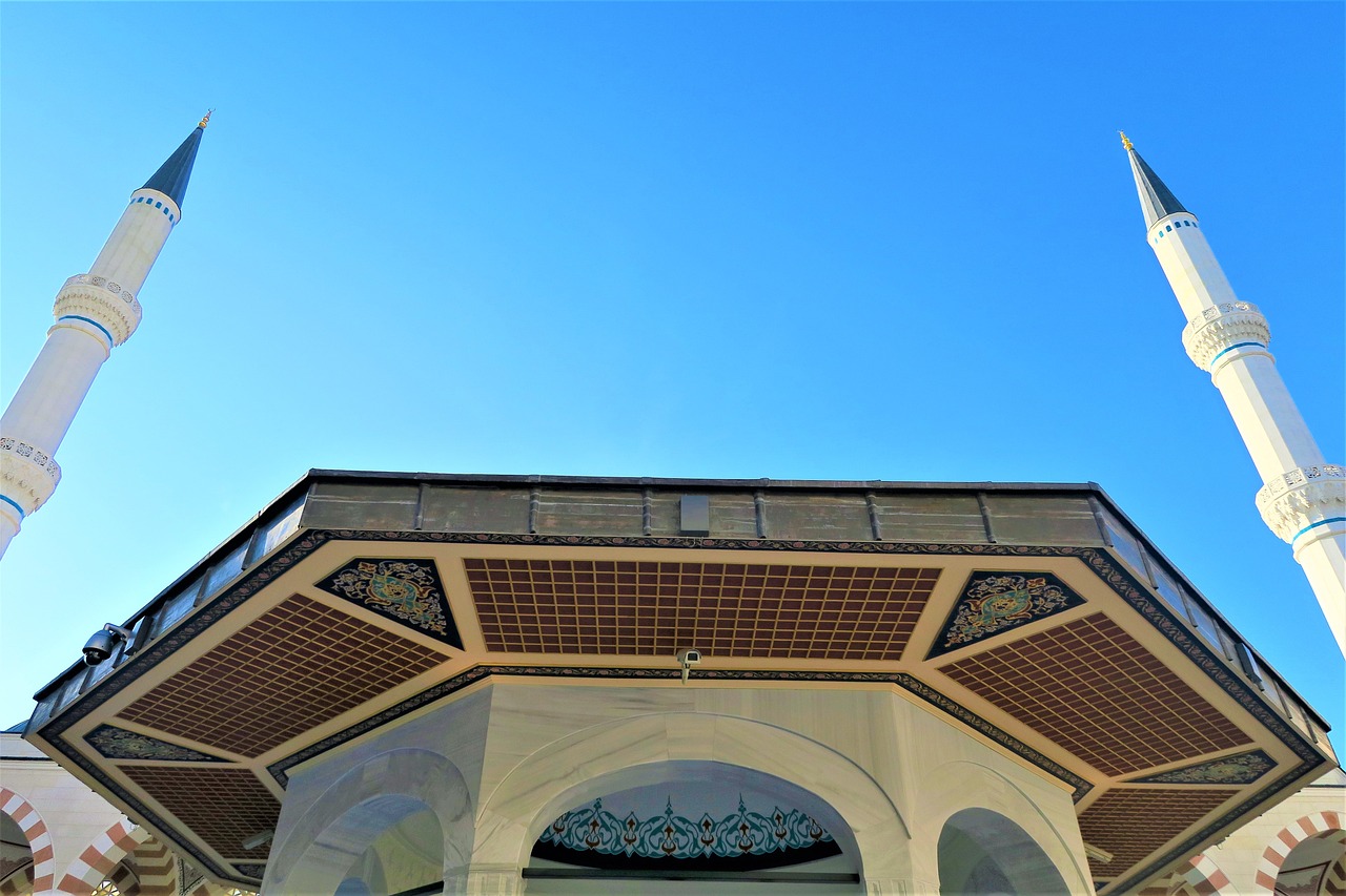 a white mosque with a blue sky in the background, a mosaic, inspired by Osman Hamdi Bey, unsplash, wooden ceiling, picture taken from the ground, islamic calligraphy, taken with a pentax k1000