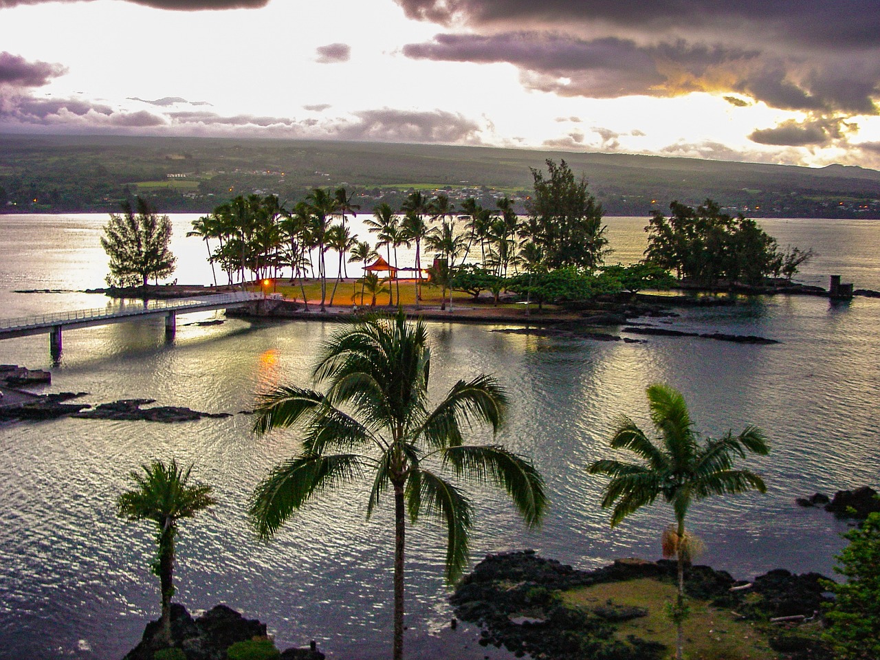 a large body of water surrounded by palm trees, a stock photo, by Jon Coffelt, big island, peaceful evening harbor, view from high, resort