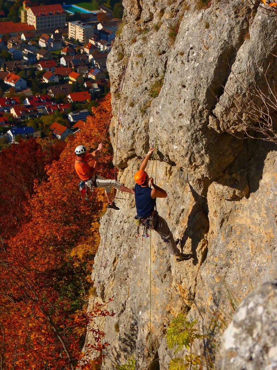 a couple of people climbing up the side of a mountain, by Erwin Bowien, shutterstock, during autumn, orange roof, training, img _ 9 7 5. raw