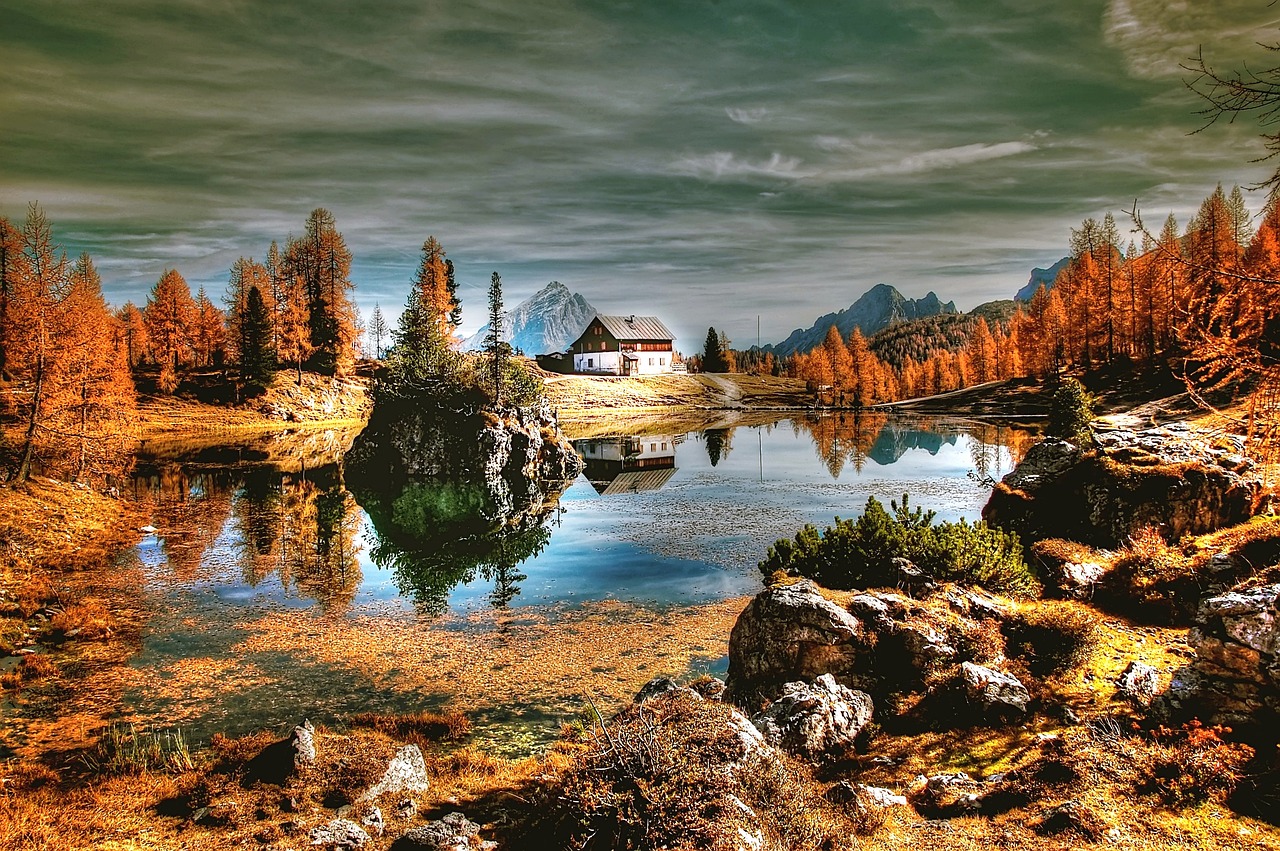 a house sitting on top of a mountain next to a lake, by Franz Hegi, flickr, romanticism, autumn! colors, lago di sorapis, wallpaper”, deep colours. ”