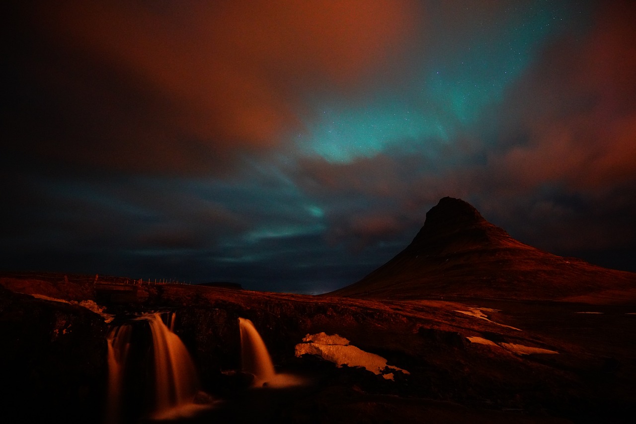 a waterfall with a mountain in the background, by Andrei Kolkoutine, tumblr, hurufiyya, nacreous lights, balaskas, cyan and orange, kieth thomsen