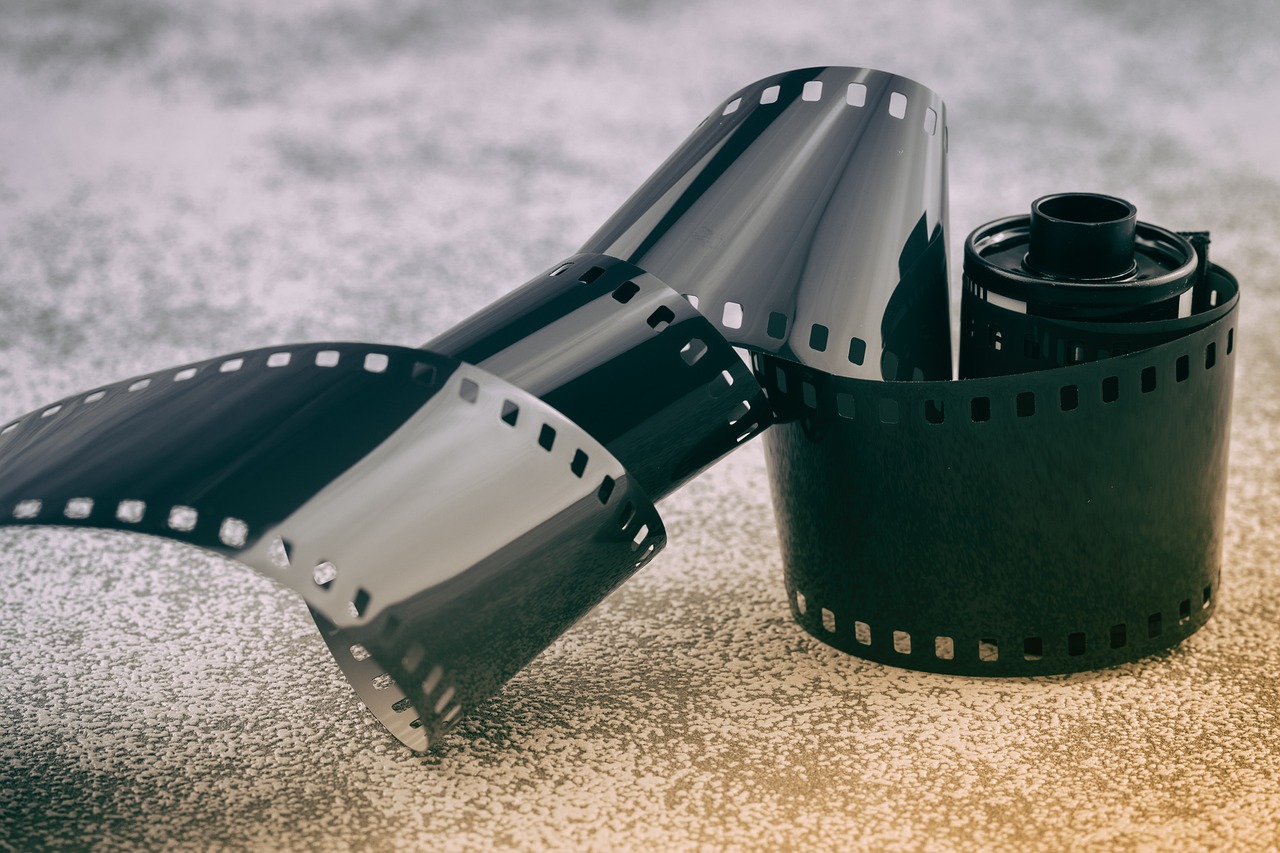 a roll of black and white film next to a roll of black and white film, a picture, unsplash, video art, 1920s film, faded color film, screenshot from a movie, camera on the ground