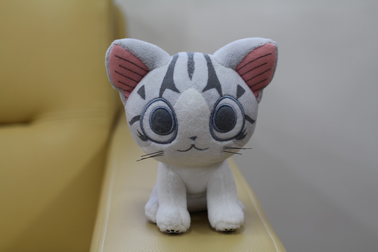 a close up of a stuffed animal on a chair, by Miyazaki, 3 d precious moments plush cat, from yowamushi pedal, large cute anime eyes, toy photo