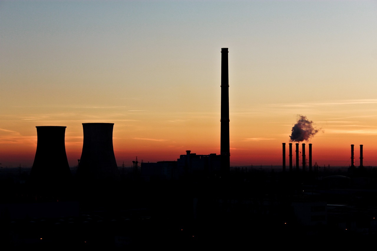 a factory with a lot of smoke coming out of it, by Hans Schwarz, flickr, silhouette over sunset, nuclear sunset, chimney with smoke, telephoto shot