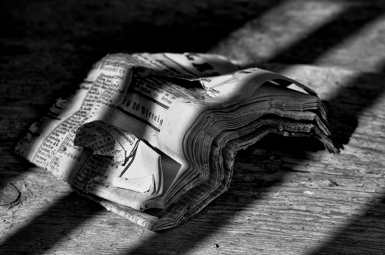 a newspaper sitting on top of a wooden floor, by Matthias Weischer, fine art, [ shards, wallpaper mobile, black and white picture, folds
