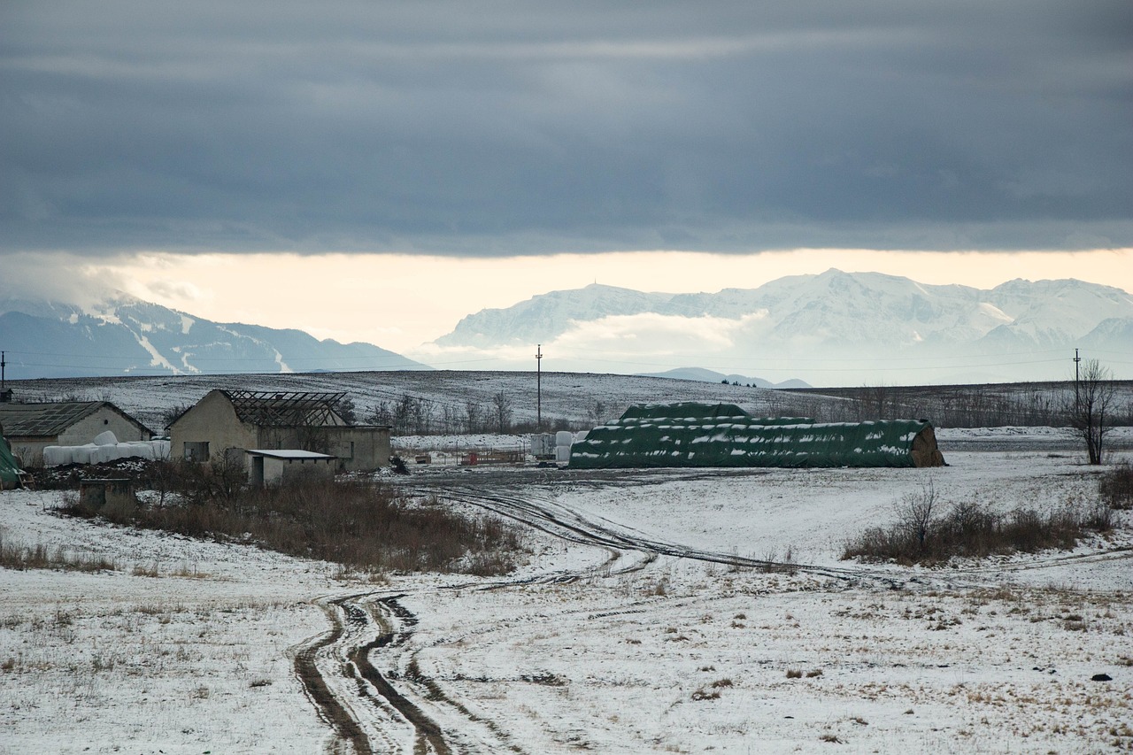 a train traveling through a snow covered countryside, a portrait, inspired by Slava Raškaj, wide view of a farm, zig-zags. mountains, overcast day, military buildings