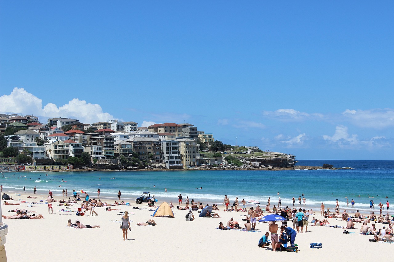 a group of people sitting on top of a sandy beach, a photo, sydney, usa-sep 20, beautiful weather, a quaint