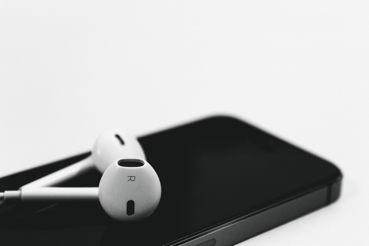 a pair of headphones sitting on top of an iphone, a black and white photo, background image, simplistic design, airpods, hyperdetailed!