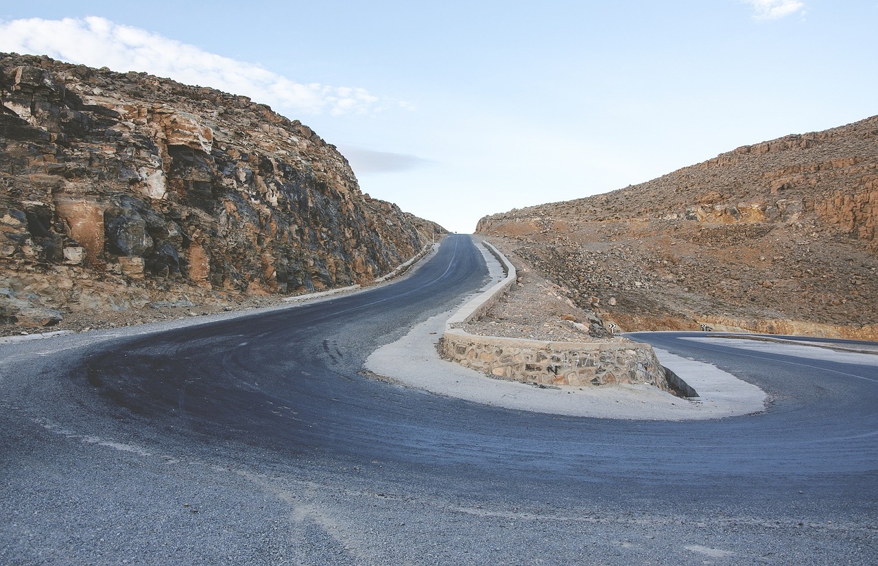 a curve in the middle of a mountain road, a picture, by Lee Loughridge, highly technical, grey, graafland, sayem reza
