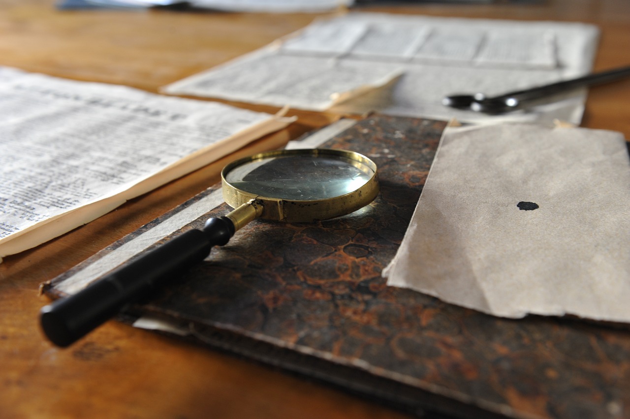 a wooden table topped with papers and a magnifying glass, a macro photograph, by Sylvia Wishart, ((sharp focus))