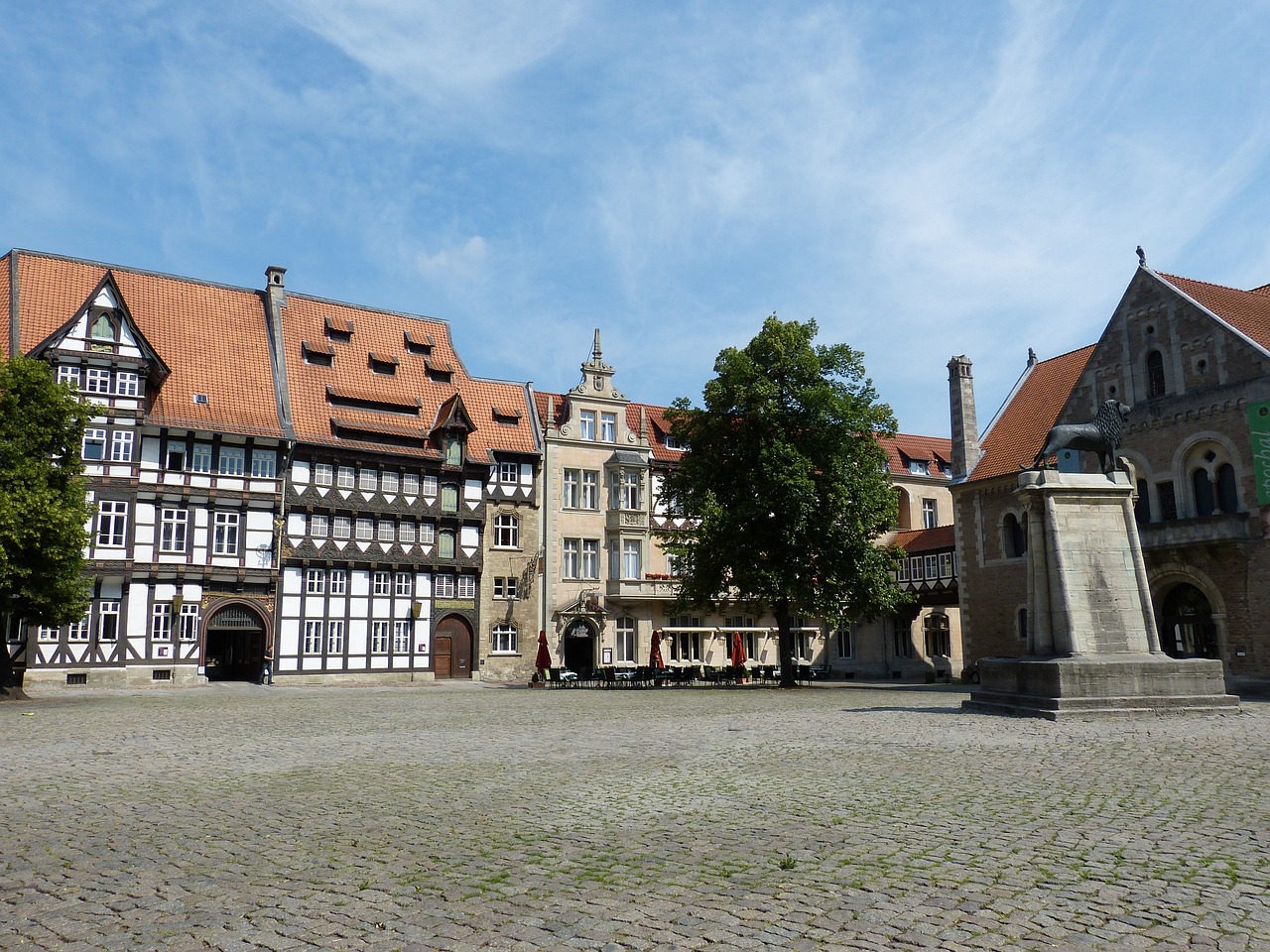 a group of buildings sitting on top of a cobblestone street, heidelberg school, sunken square, big arches in the back, wooden buildings, portlet photo