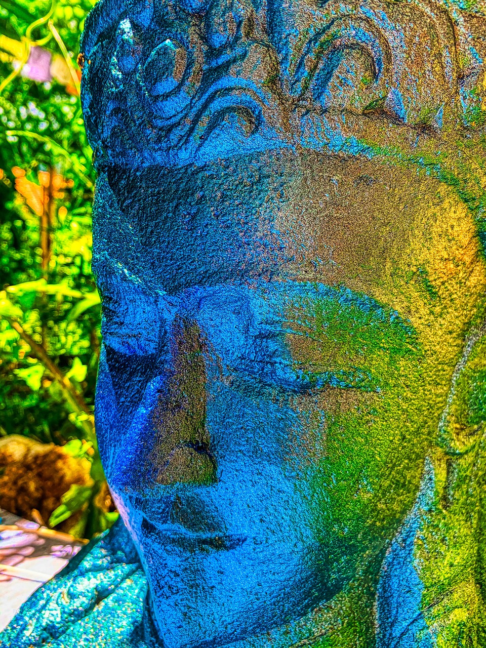 a close up of a statue of a person, concrete art, iridescent accents. vibrant, buddha, in marijuanas gardens, warm shades of blue