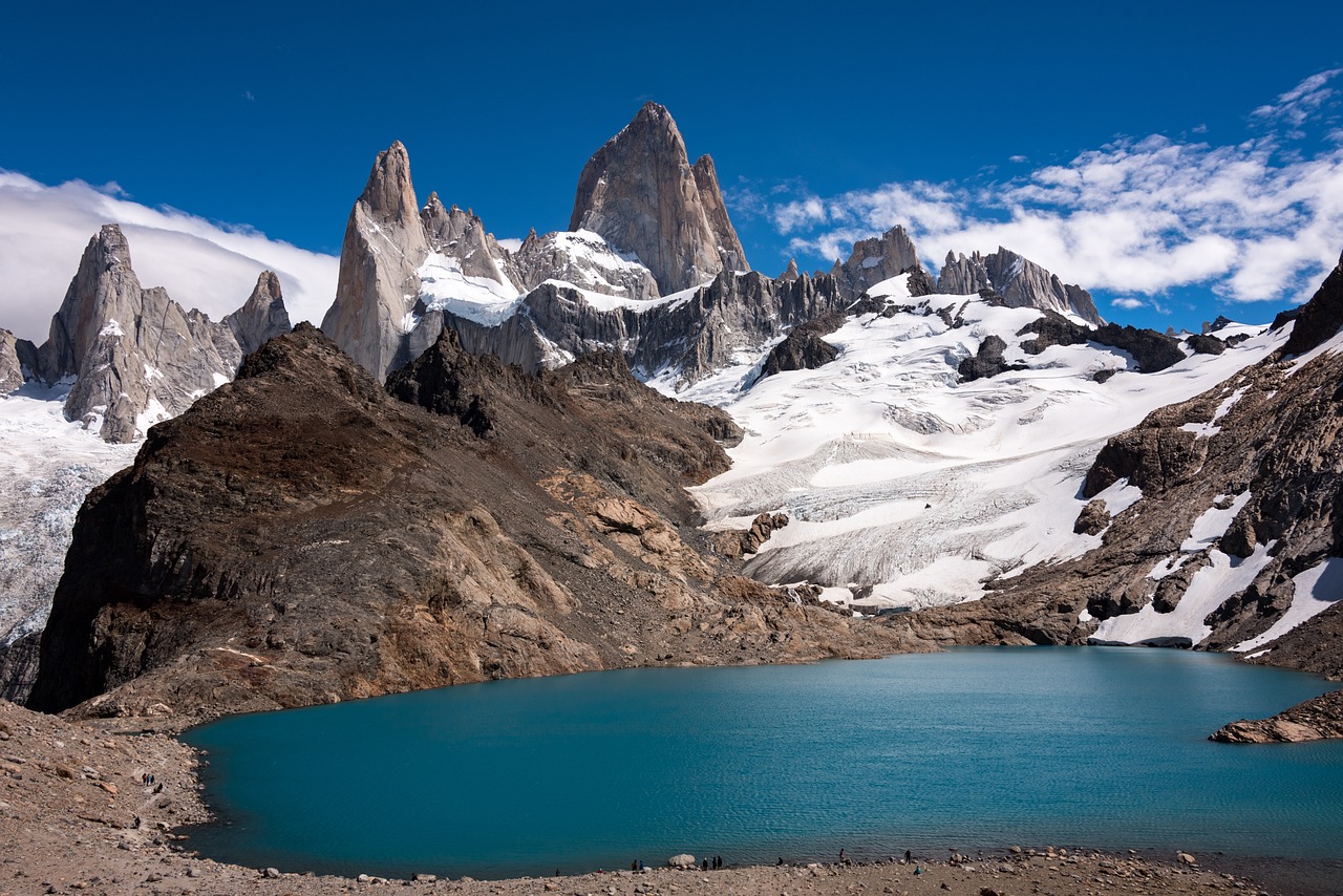 a body of water surrounded by snow covered mountains, by Juan Carlos Stekelman, trending on shutterstock, tall stone spires, devils horns, chocolate, buenos aires