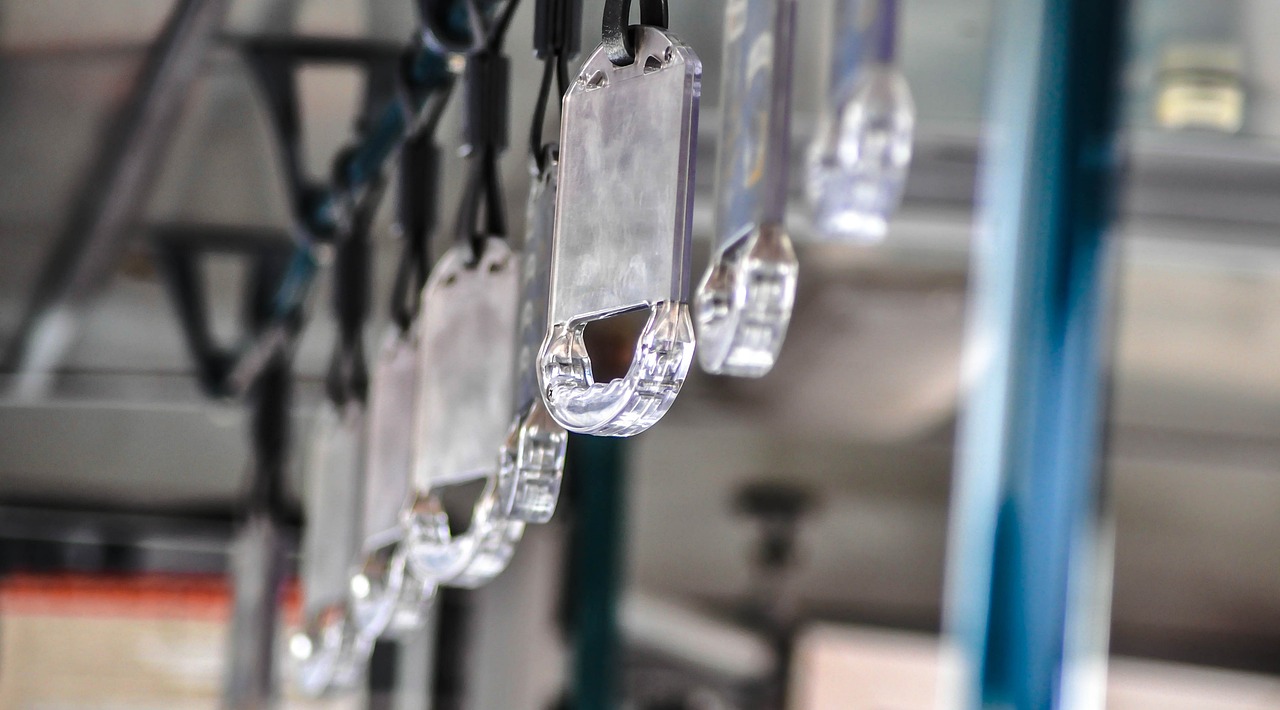 a bunch of tags hanging from a metal pole, reflection of led lights, manufacturing, crystal-clear-focus, cryogenic pods